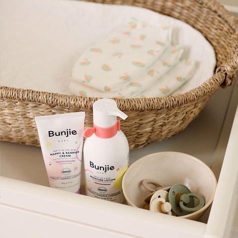 Baby changing table with nappies, bibs, and nappy cream
