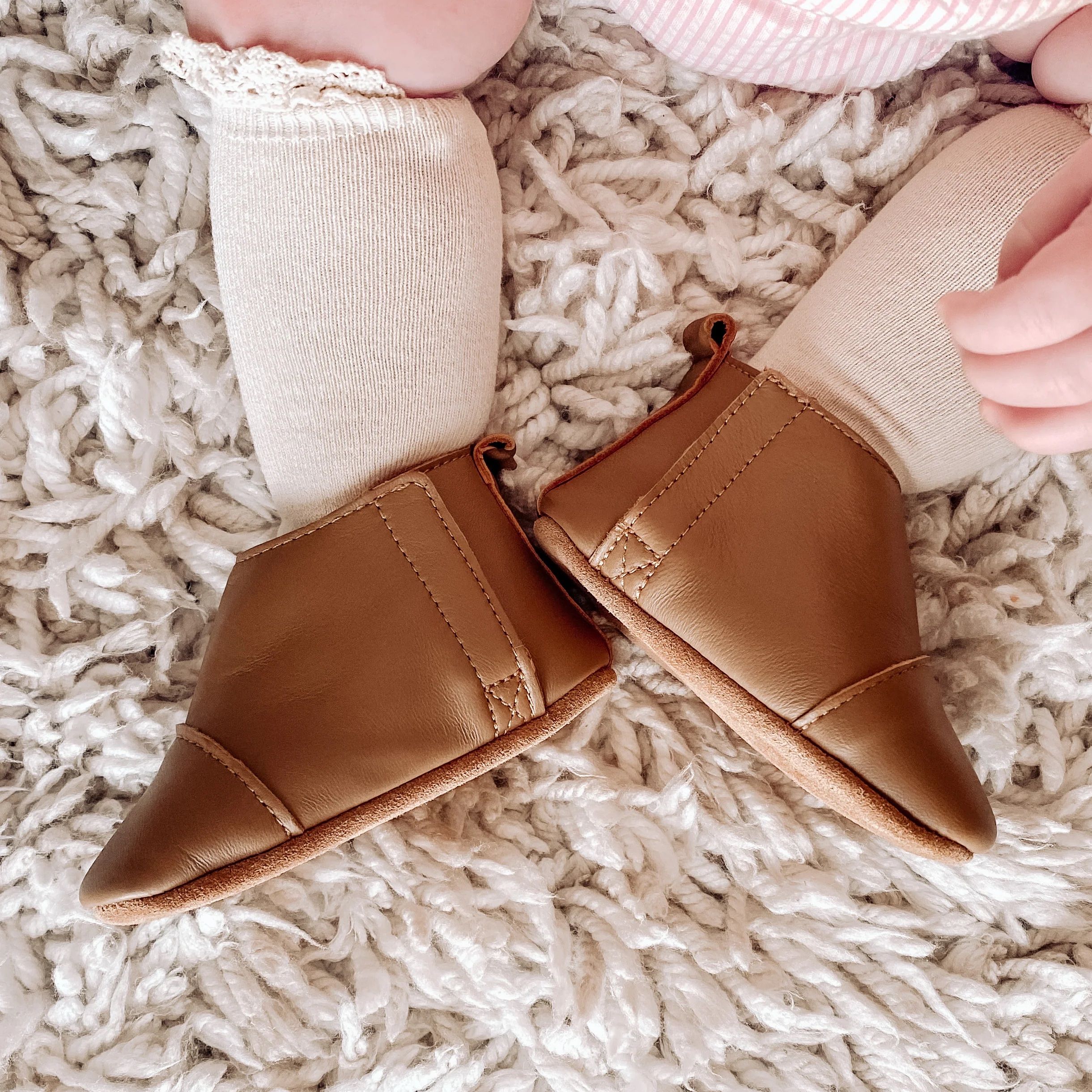 Baby wearing leather boots and long socks